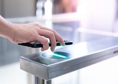 hand holding smartphone near modern turnstile with green light indicating access to eight facilities