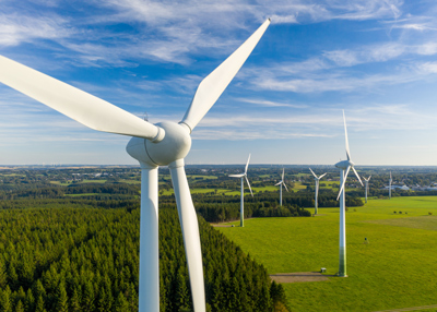 wind turbines in a green landscape with blue sky featuring multiple turbines spread out across the field